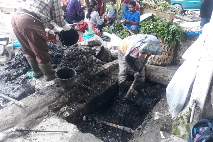 Petugas Dinas PUPR Kabupaten Karo saat memperbaiki drainase di Jalan Perniagaan Berastagi