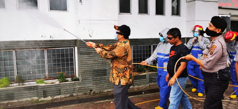 Bupati Karo Terkelin Brahmana SH didampingi Ketua gugus Ir Martin Sitepu melakukan peyemprotan seputar gedung DPRD Karo dengan menggunakan pakaian lengkap topi dan masker disaksikan tim Gugus tugas