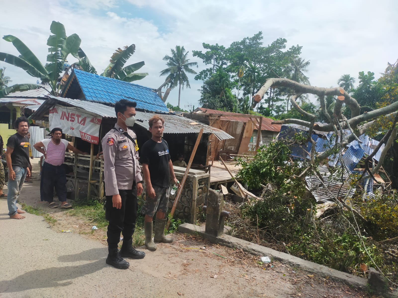 Bhabinkamtibmas Polsek Medang Deras bergotong royong bersama warga membersihkan kayu pohon yang tumbang (foto : HumaspolresBB)