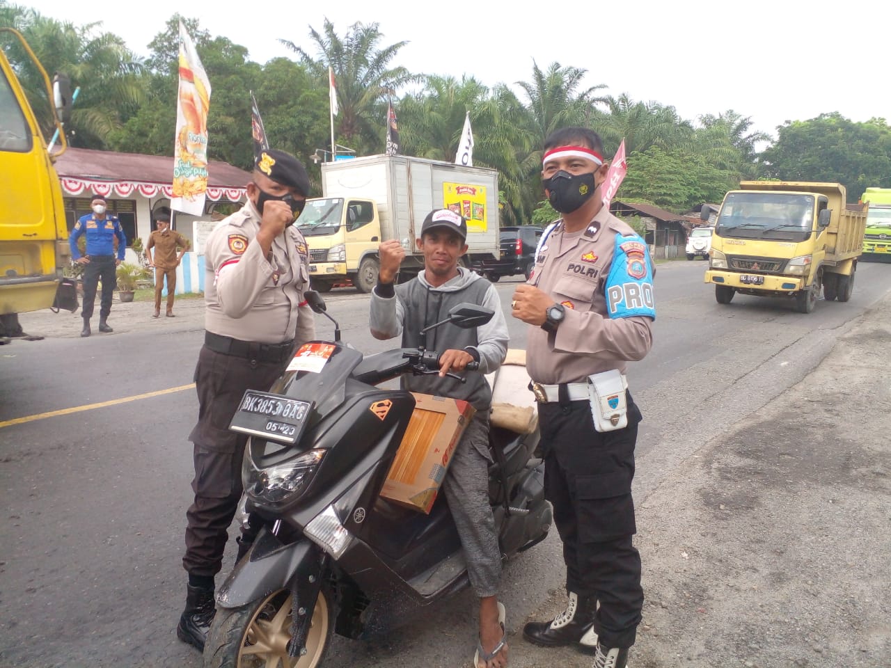 Personel Polsek Labuhan Ruku saat memberikan bendera merah putih kepada masyarakat (foto: HumaspolresBB)