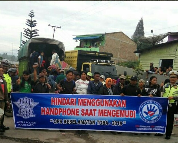 Sat Lantas Polres Tanah Karo berfoto usai melakukan sosialisasi dengan pengendara.