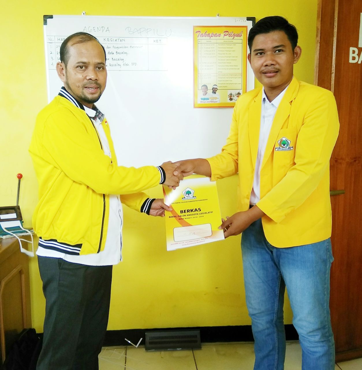 Fajar Adithya Paksi (kanan) saat menyerahkan berkas kelengkapan administrasi pencalonan kepada Sekjend DPD Golkar, Suryana (kiri).