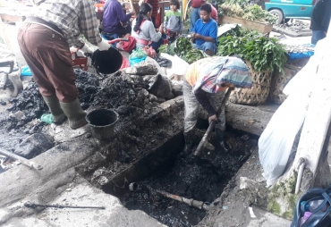 Petugas Dinas PUPR Kabupaten Karo saat memperbaiki drainase di Jalan Perniagaan Berastagi