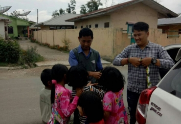 Amsalta Sinuhaji saat berbagi cemilan dengan anak-anak